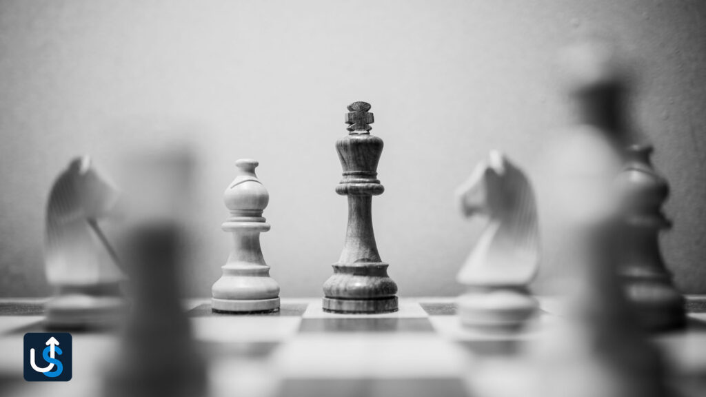A black and white photo of chess pieces on a chess board.