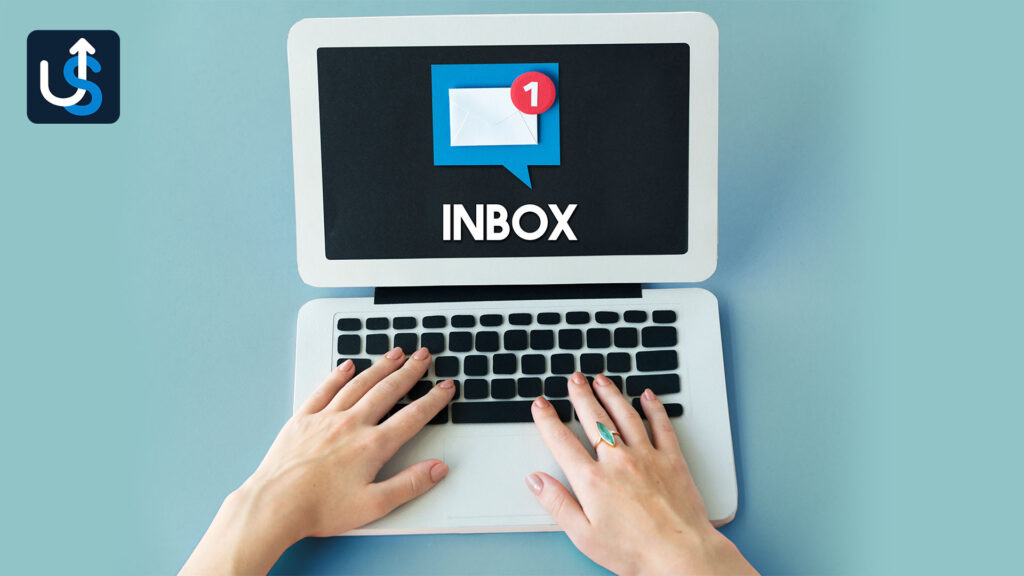A person typing on a laptop with the word inbox on it.