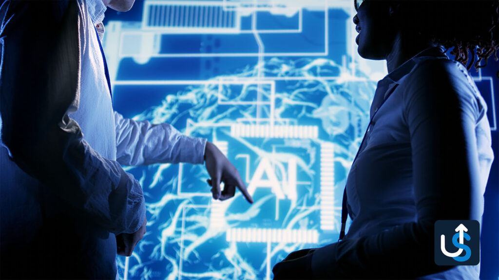 Two people discuss in front of a large digital screen displaying AI-themed graphics and circuitry. One person points to the screen.