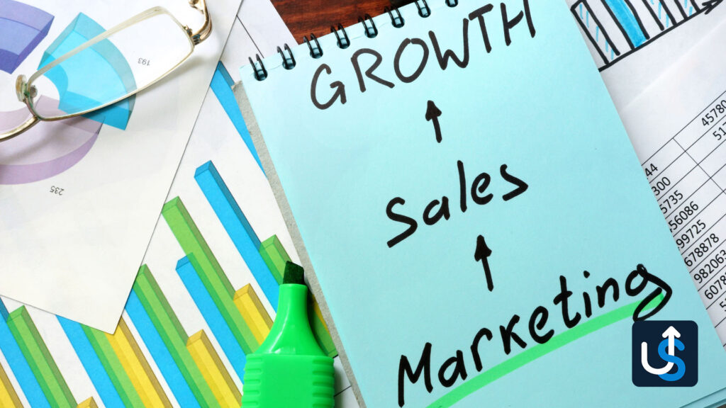 Notebook with "GROWTH," "Sales," and "Marketing" written on it, surrounded by colorful charts, a highlighter, glasses, and a guide to CRM for agencies.