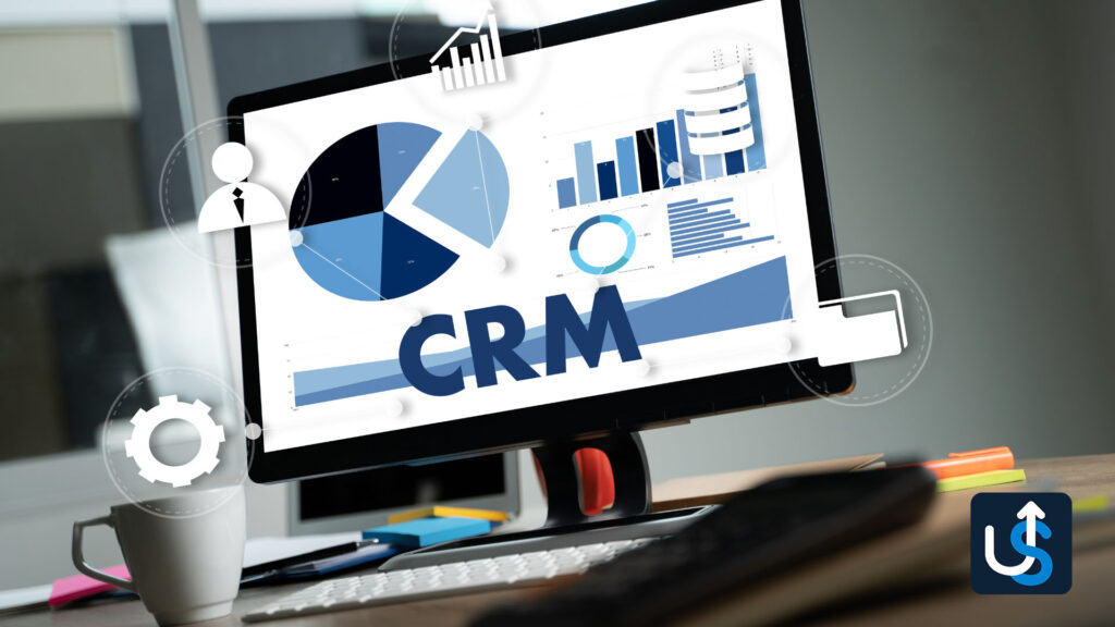 A computer monitor displays a CRM For Agency dashboard with various charts and graphs, surrounded by business-related icons.