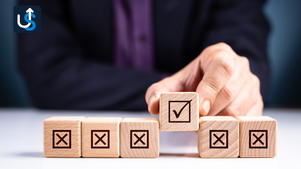 A person arranges wooden blocks with checkboxes and crosses; one block with a checkmark is prominent.