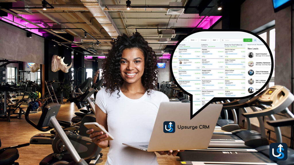 A woman in a gym holds a phone and laptop displaying a CRM dashboard. Exercise equipment surrounds her.